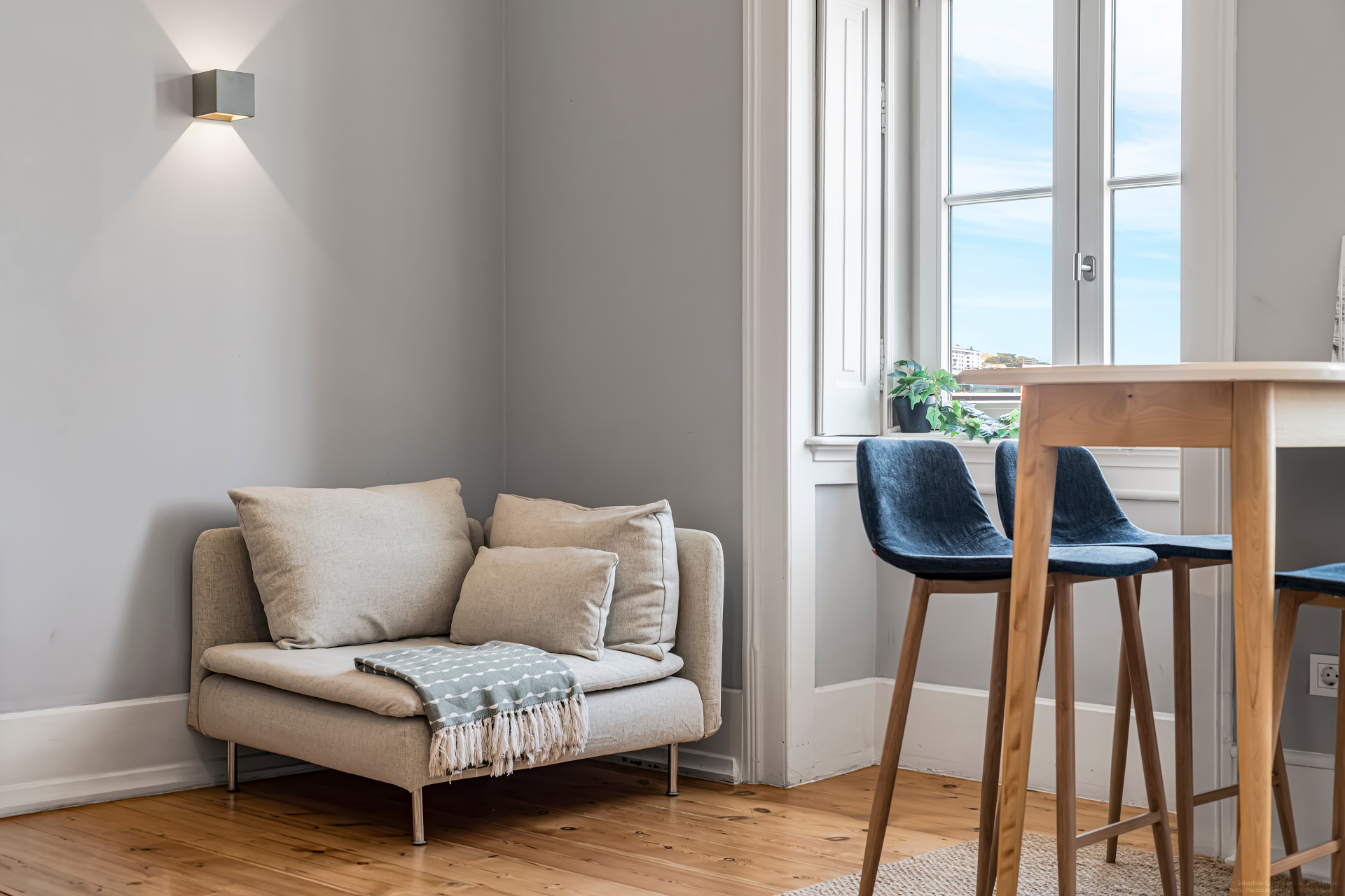 Quiet seating corner beside tall windows inside the apartment