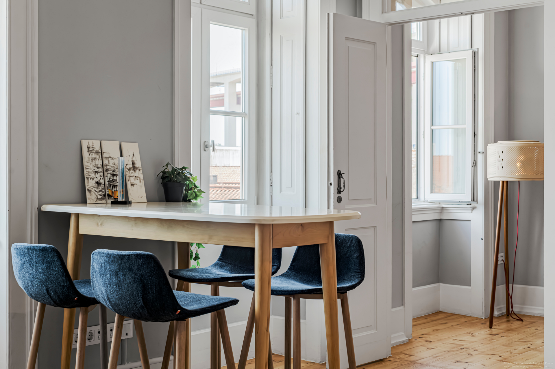 Breakfast area with elevated table, blue chairs and open shutters